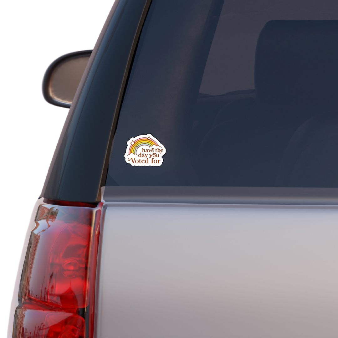 Retro rainbow sticker with the phrase “Have the Day You Voted For” in bold brown text and sparkles