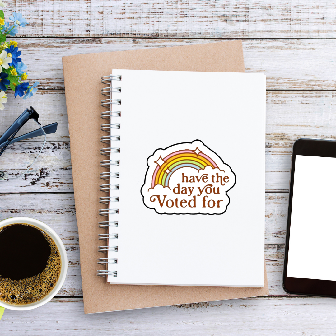 Retro rainbow sticker with the phrase “Have the Day You Voted For” in bold brown text and sparkles