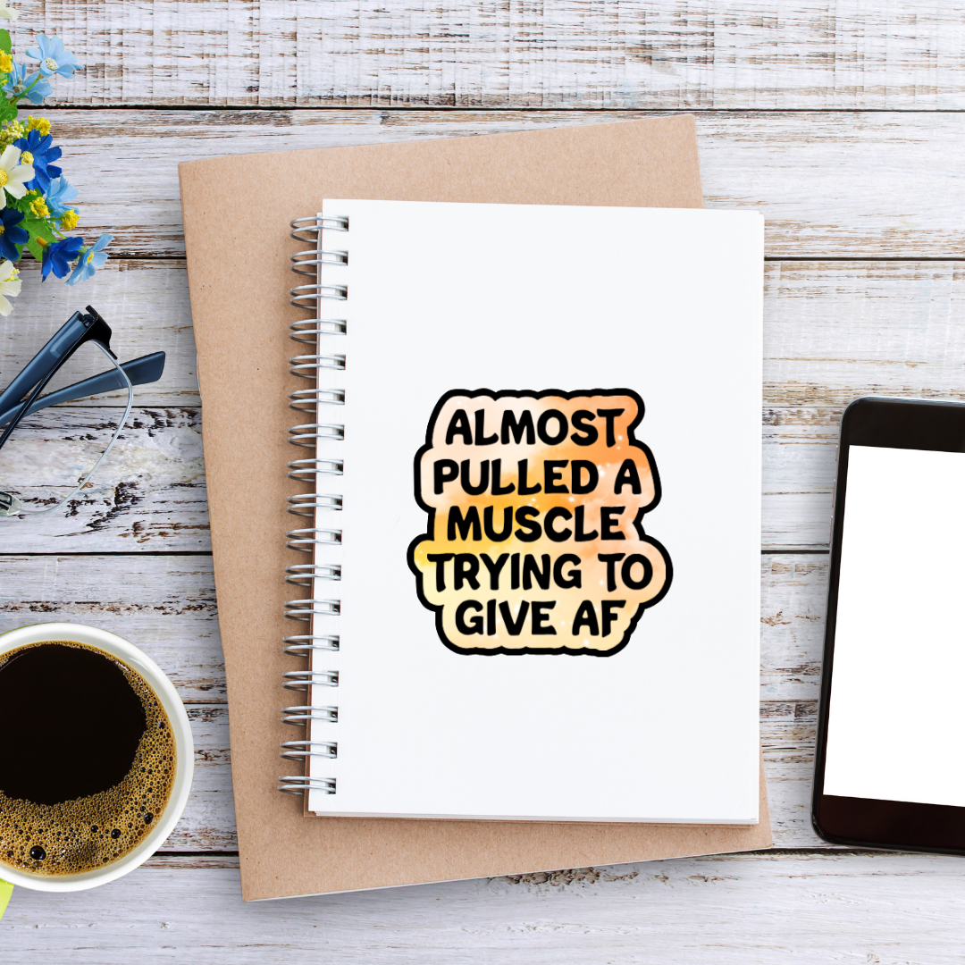 Holographic sticker that reads “Almost pulled a muscle trying to give AF” in bold black text over a peach-pink sparkle background