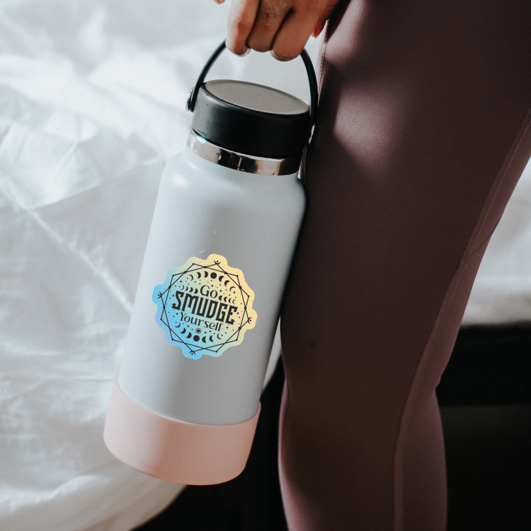 Holographic sticker with moon phases, sacred lines, and the phrase “Go Smudge Yourself” in bold black letters