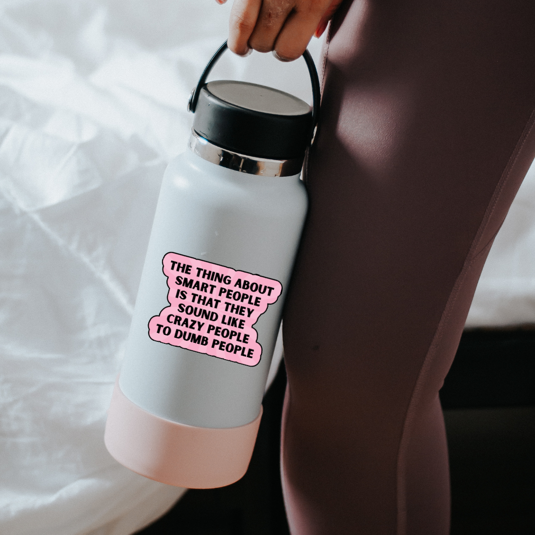 Holographic sticker with the quote “The thing about smart people is that they sound like crazy people to dumb people” in bold black lettering