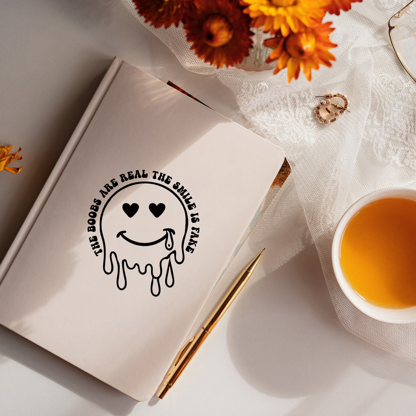 Vinyl decal of a dripping smiley face with heart eyes and a tear, surrounded by text that reads “The Boobs Are Real The Smile Is Fake”