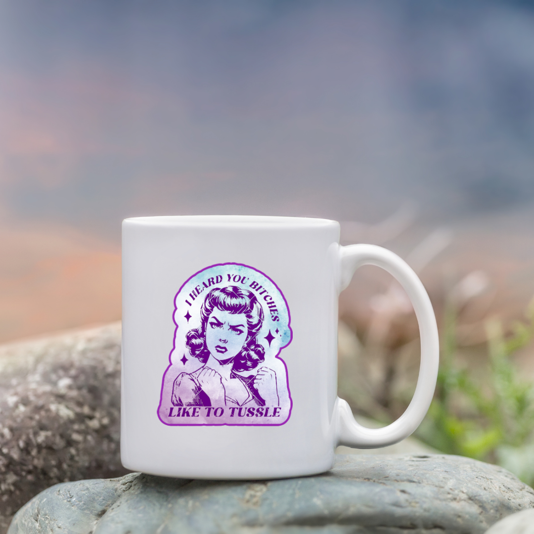 Sticker featuring a vintage-style woman with fists up and the phrase “I Heard You Bitches Like to Tussle” in purple and teal tones