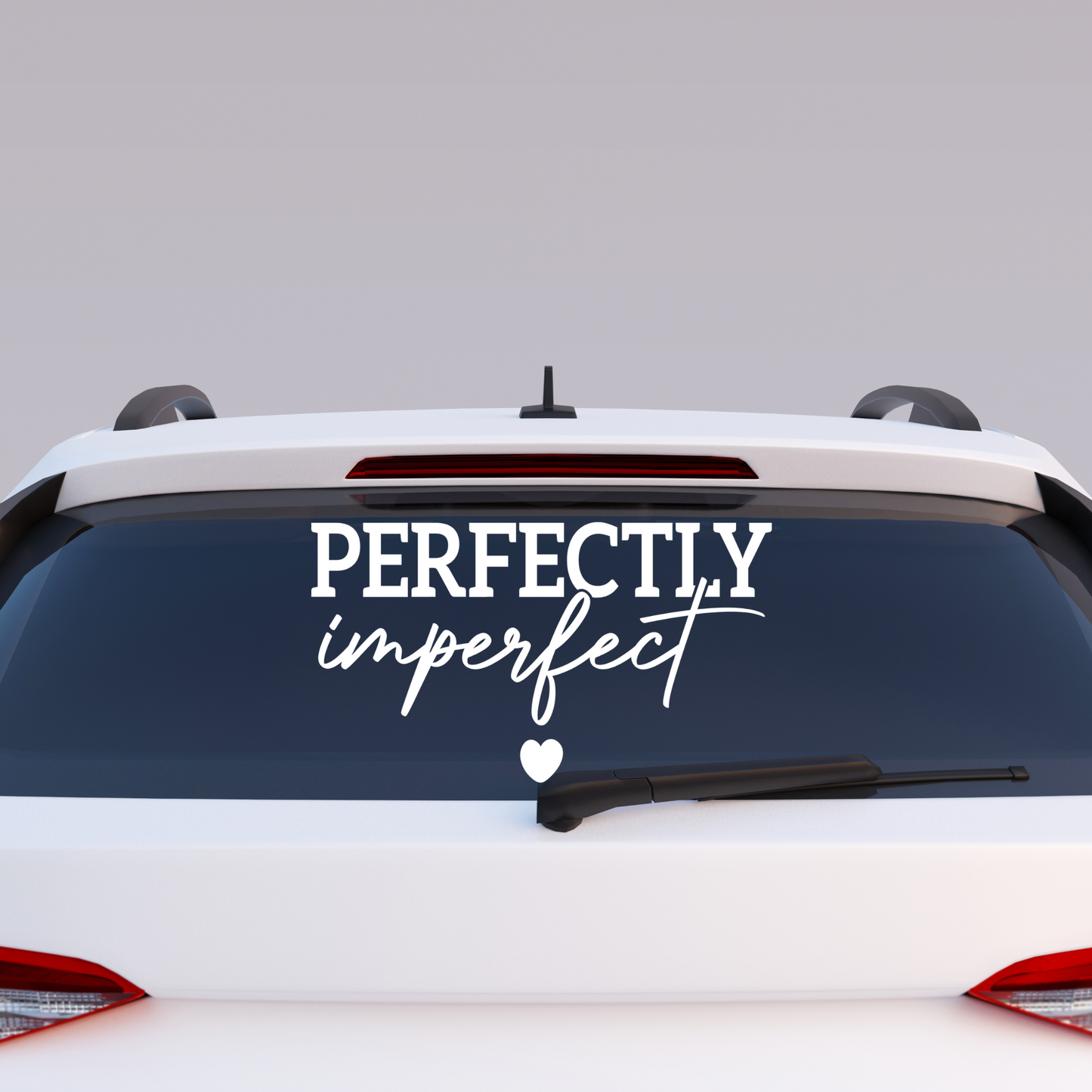 Car with 'PERFECTLY imperfect' decal on the back window against a gray background