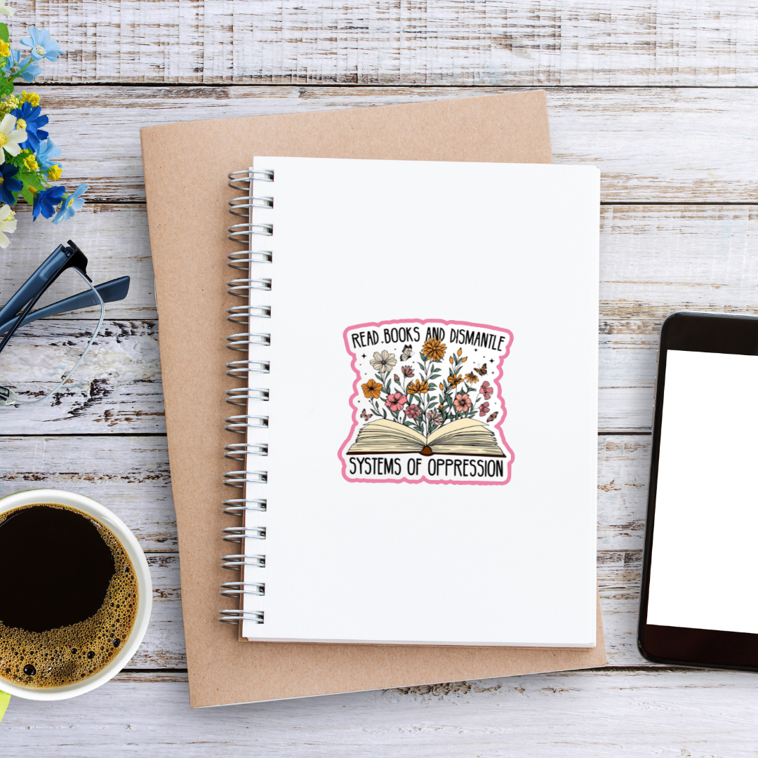 Notebook with a motivational sticker on a wooden surface with a cup of coffee and tablet.