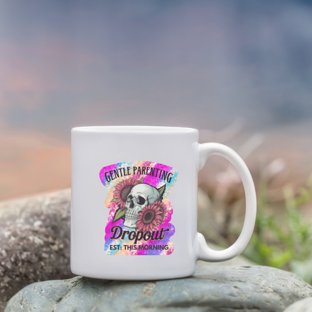 White mug with colorful design featuring a skull and text on a rock with a blurred natural background