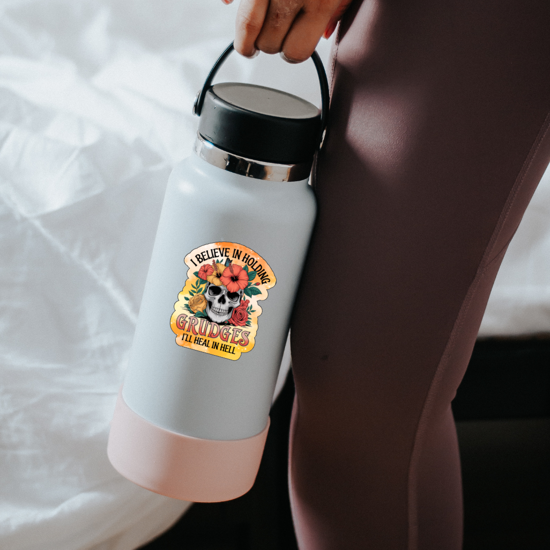 White and pink water bottle with a skull design held by a person on a white background