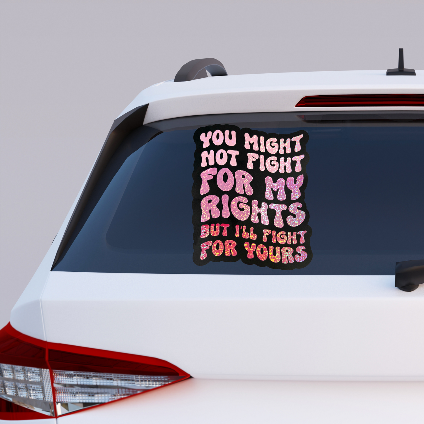 Car with a decal on the back window featuring text.