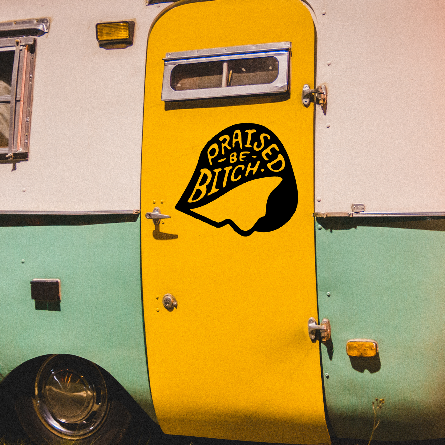 Yellow door of a vintage trailer with a graphic design and text.