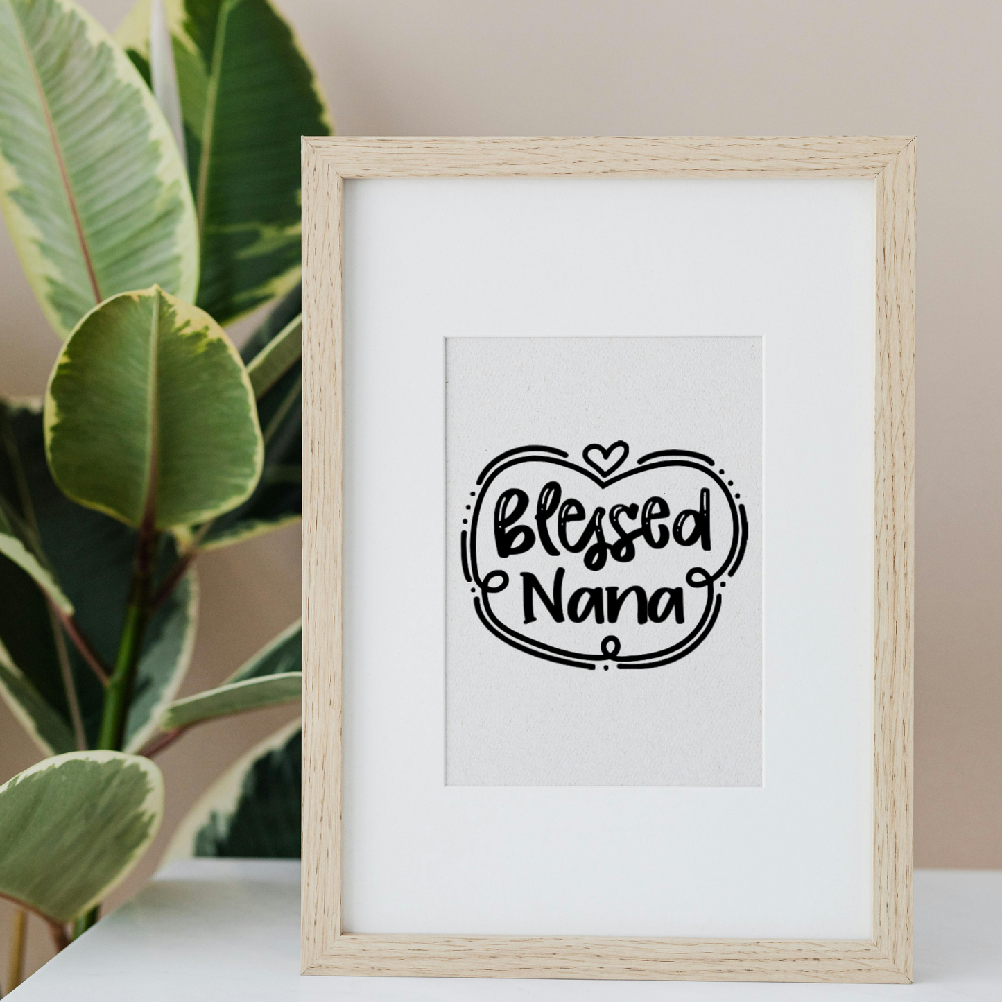 Black vinyl decal that reads “Blessed Nana” in playful hand lettering with heart and swirly border design