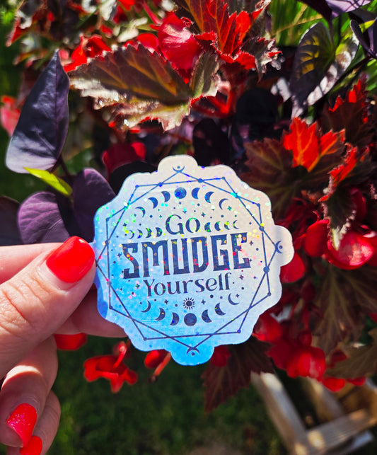 Holographic sticker with moon phases, sacred lines, and the phrase “Go Smudge Yourself” in bold black letters