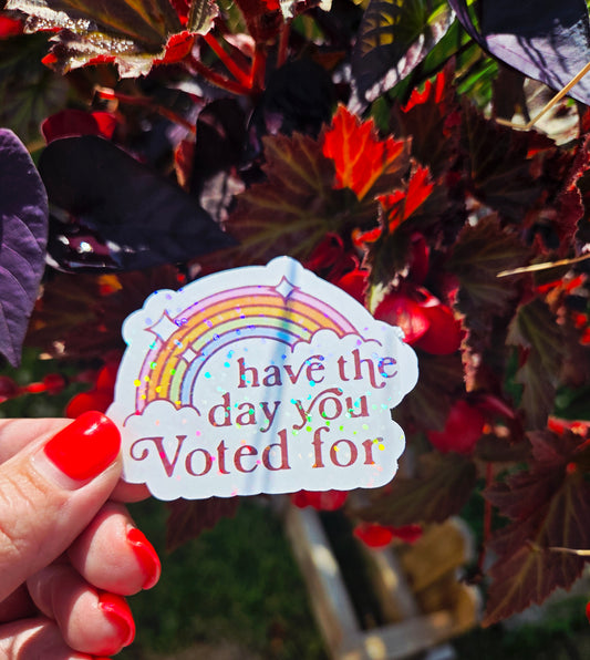 Retro rainbow sticker with the phrase “Have the Day You Voted For” in bold brown text and sparkles