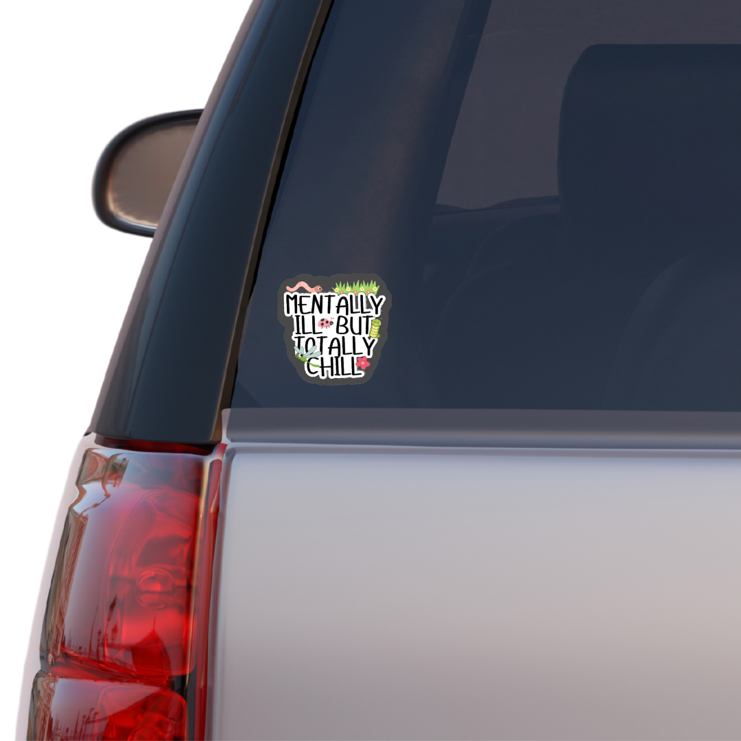 Holographic sticker that says “Mentally Ill But Totally Chill” with bugs, grass, and sparkles