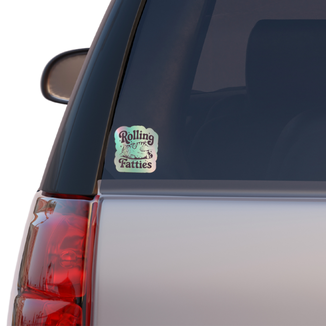 Holographic sticker with a hand rubbing a fat, relaxed cat and the phrase “Rolling Fatties” in playful black text