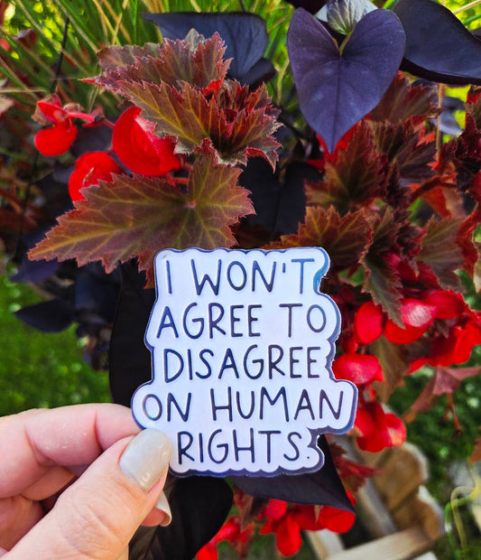 Sticker with handwritten-style text that says “I won’t agree to disagree on human rights” in bold black on white