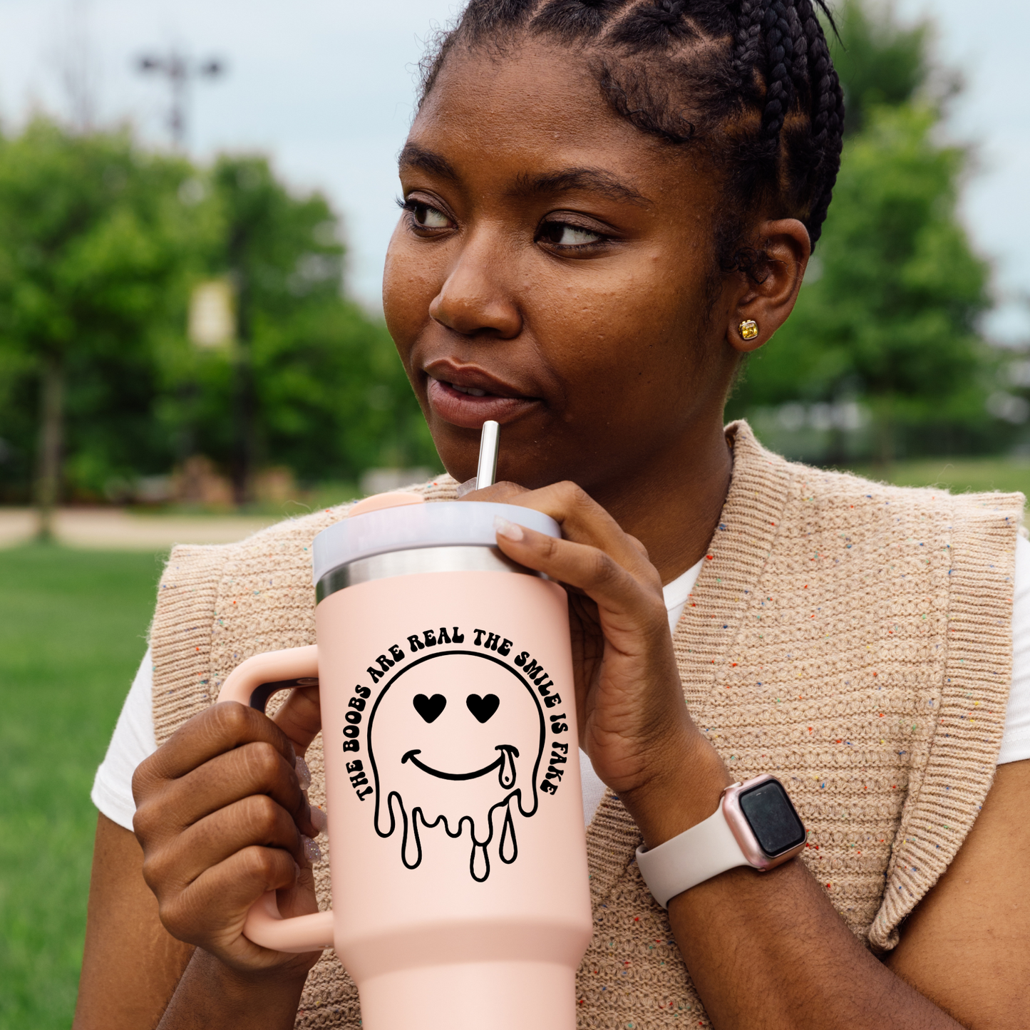 Vinyl decal of a dripping smiley face with heart eyes and a tear, surrounded by text that reads “The Boobs Are Real The Smile Is Fake”