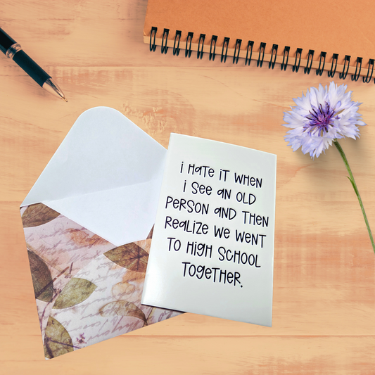 Note with humorous text on a wooden surface with a pen and flower.