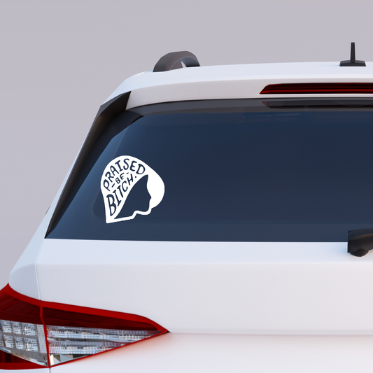 Car with a 'Raised as a Bitch' decal on the rear window against a gray background