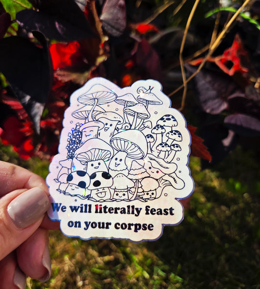 Holographic vinyl sticker with illustrated mushrooms and the phrase “We will literally feast on your corpse” in black text