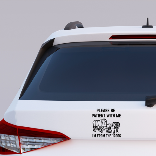 Black and white funny vinyl sticker with a covered wagon and two horses. Text reads: "Please be patient with me – I'm from the 1900s." Ideal for millennial humor lovers.